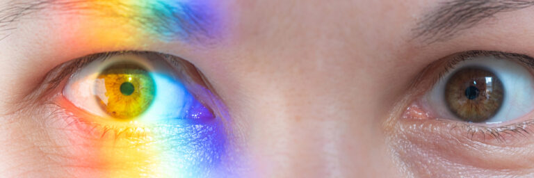 Corneal topography scan highlighting keratoconus irregularity with rainbow reflection across the eye