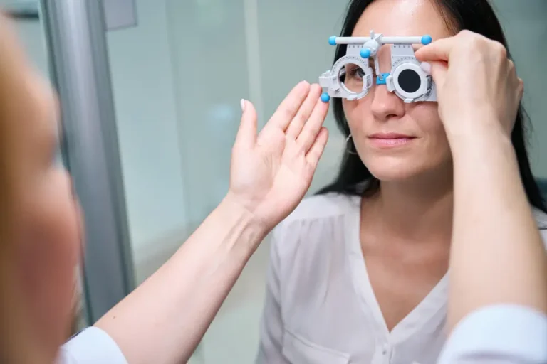 Optometrist fitting vision test device on woman before scleral lens evaluation