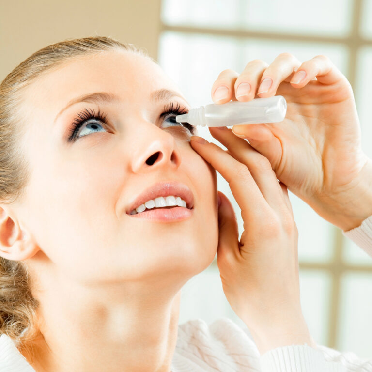 Young woman applying artificial tears for dry eyes relief